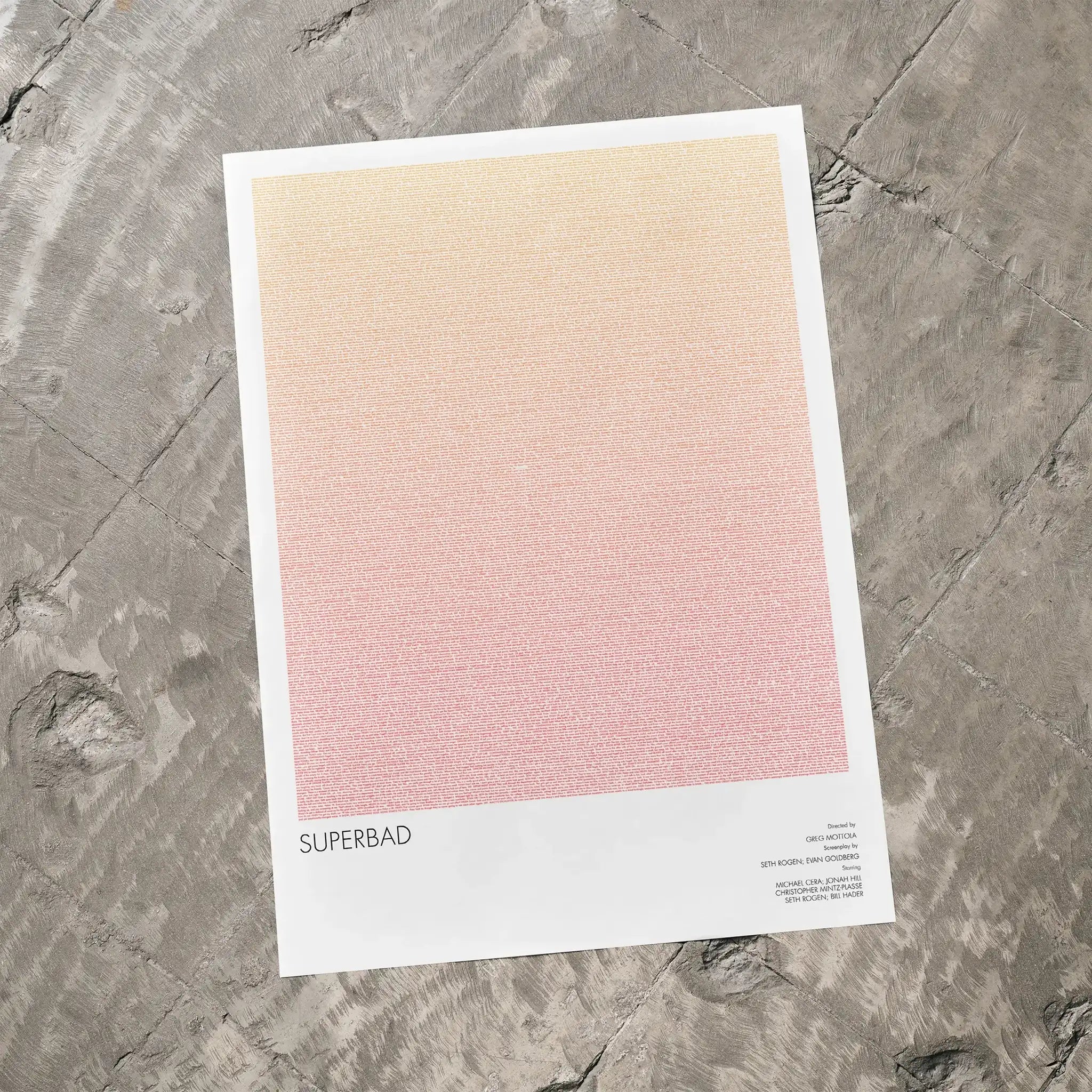 A Superbad movie script poster laid flat on a textured floor surface.