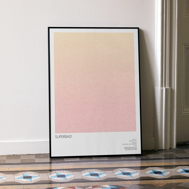 A framed Superbad movie script poster leaning against a wall in a minimalist interior.
