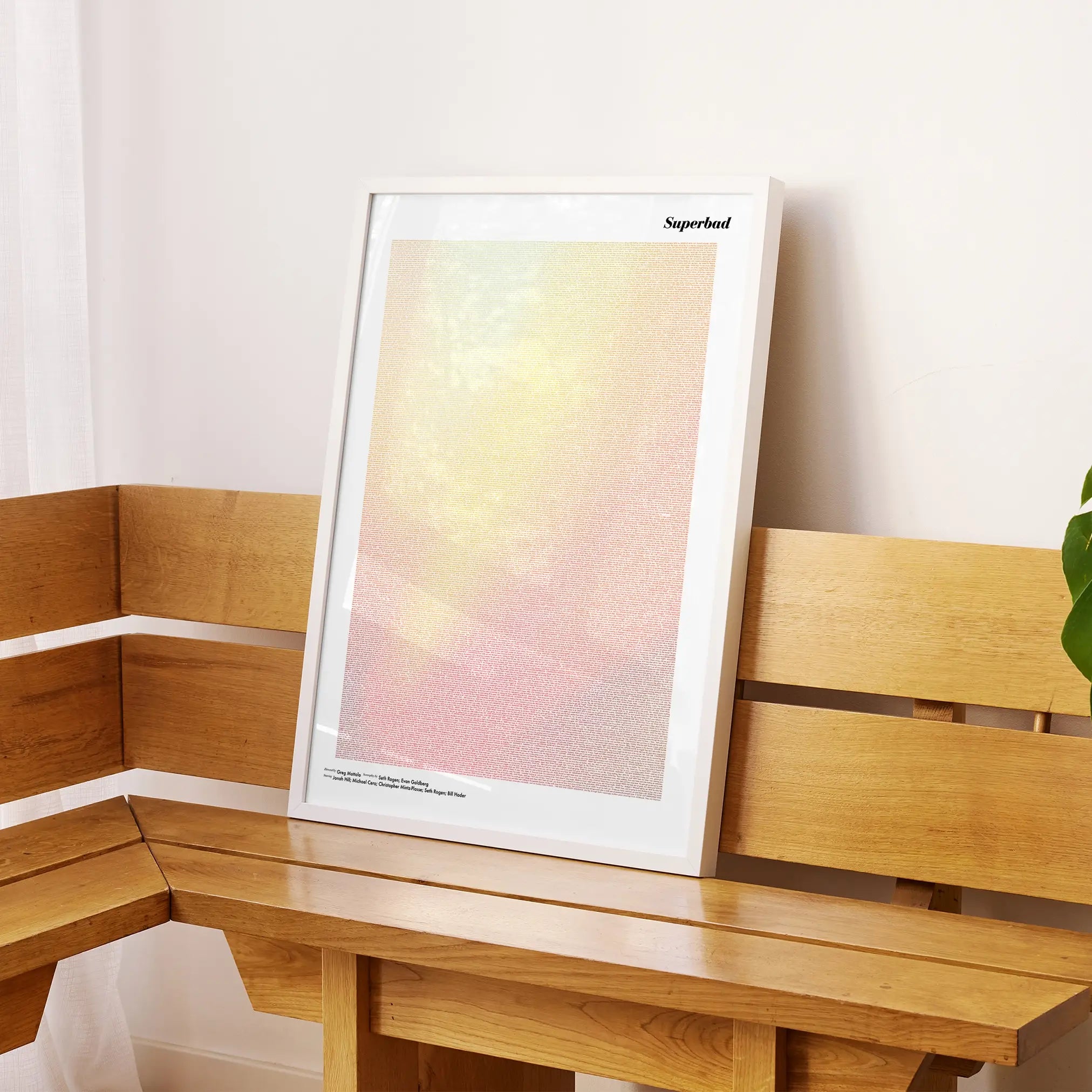 A framed Superbad movie script poster displayed on a sideboard in a contemporary space.