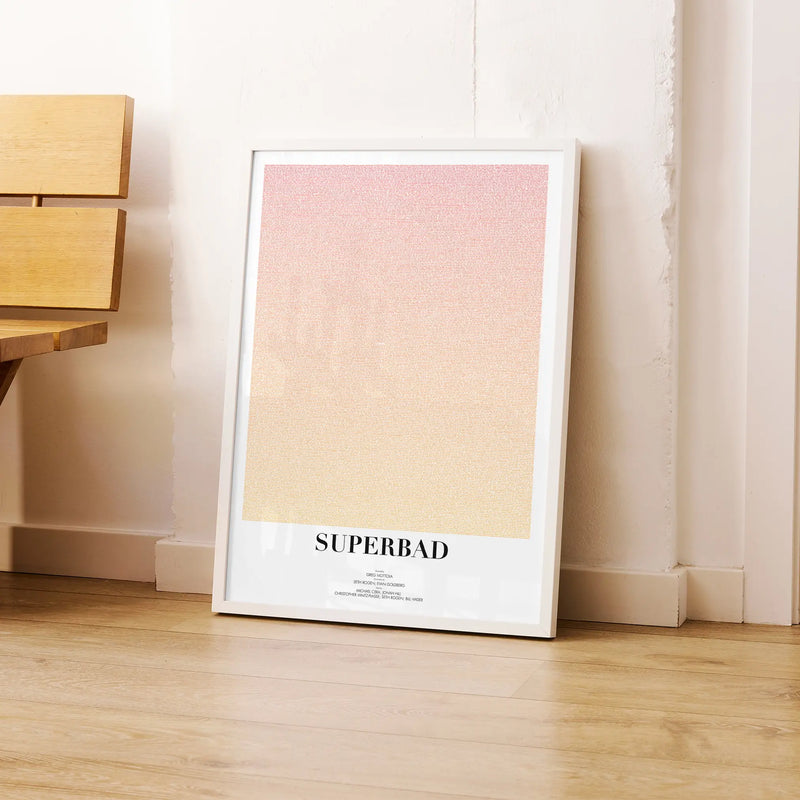A framed Superbad movie script poster leaning against a wall in a modern interior.