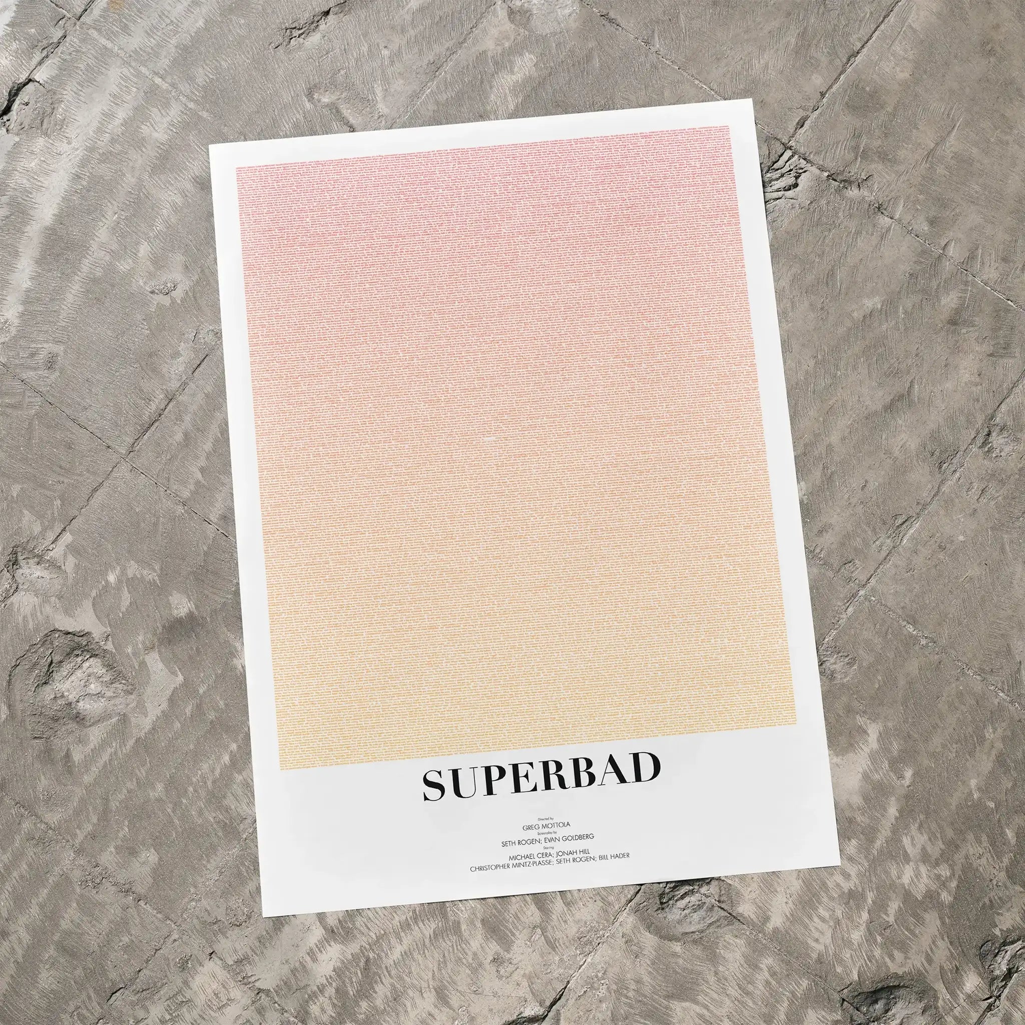 A Superbad movie script poster laid flat on a textured floor surface.