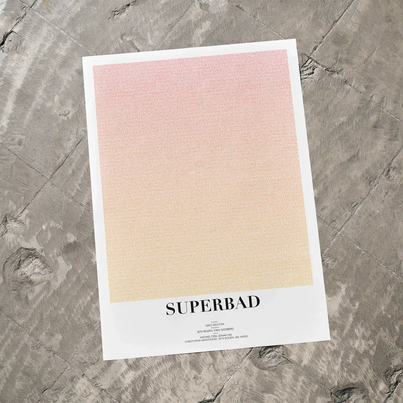 A Superbad movie script poster laid flat on a textured floor surface.