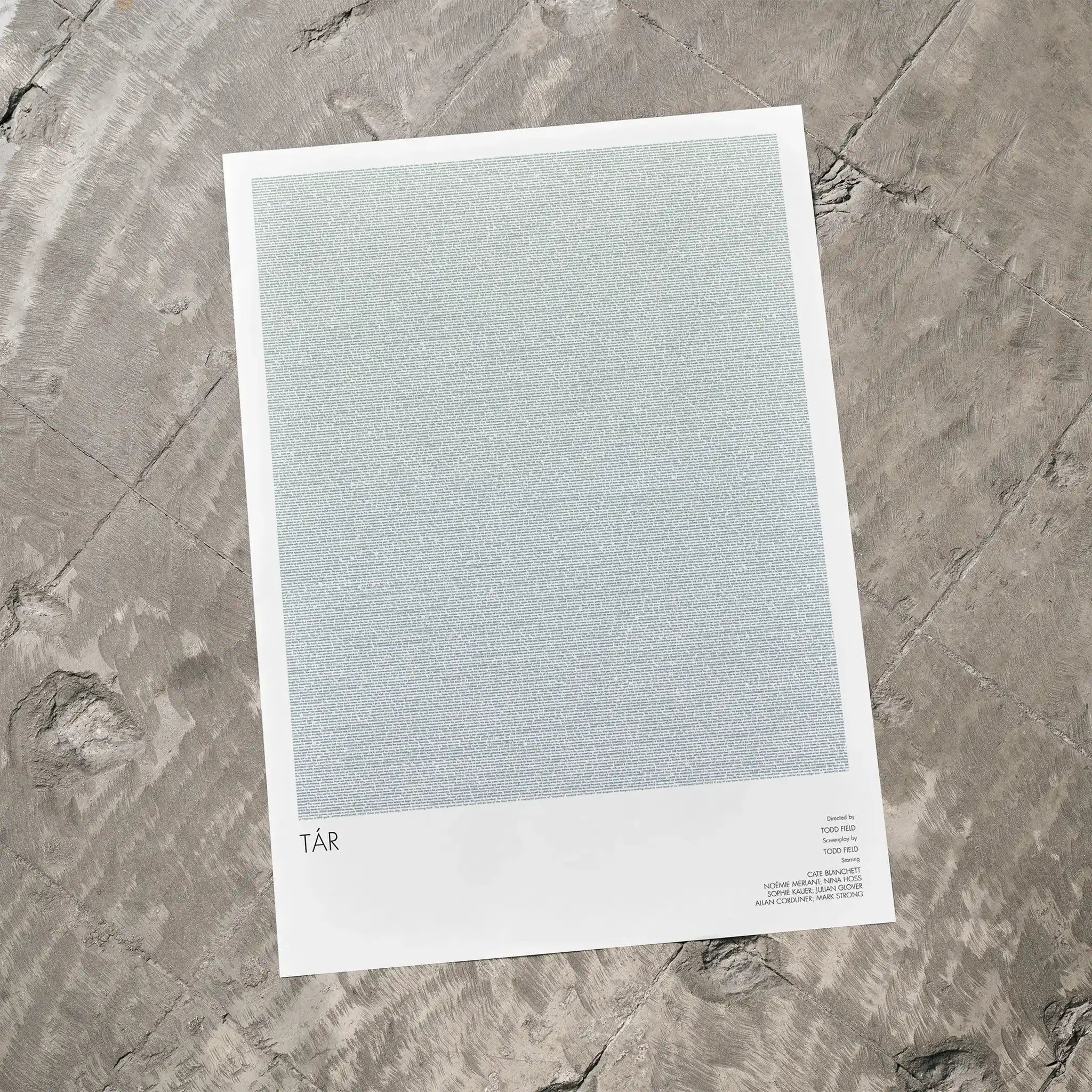 A Tár movie script poster laid flat on a textured floor surface.