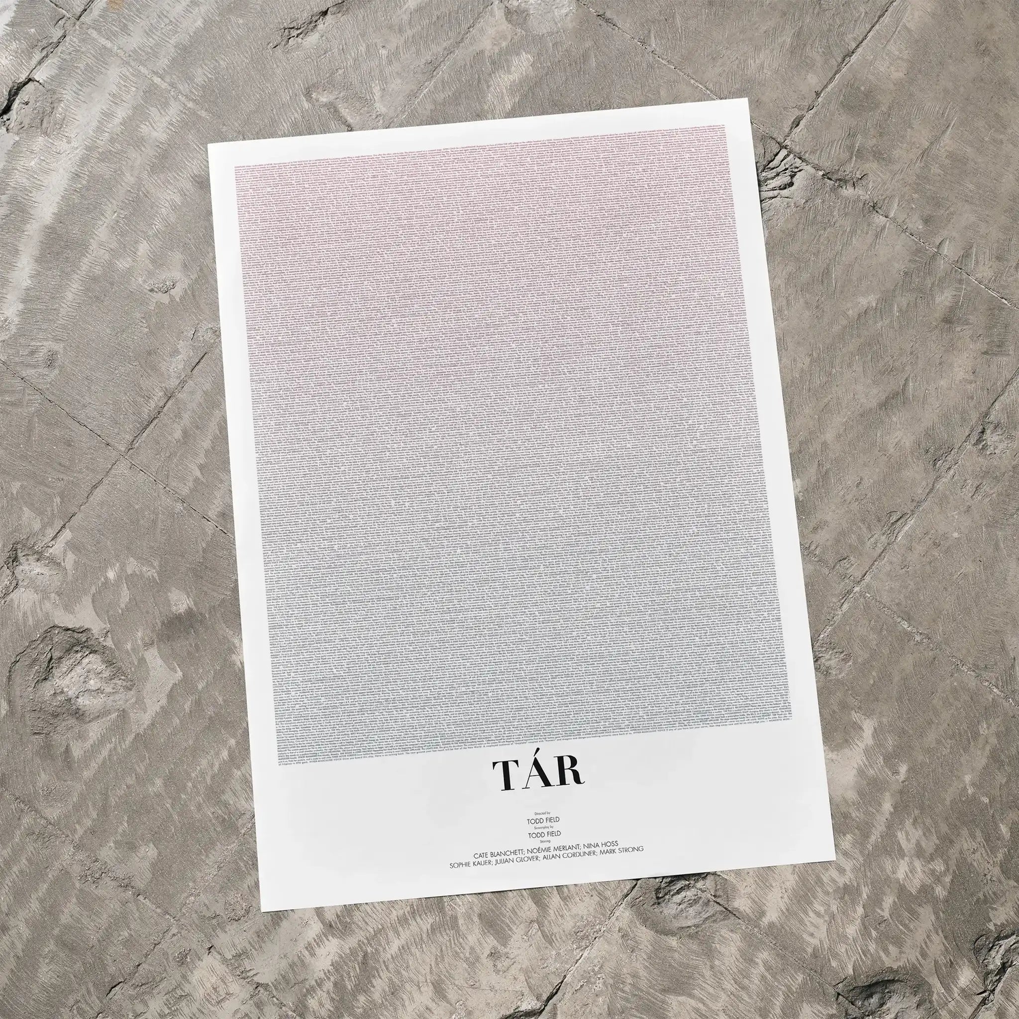 A Tár movie script poster laid flat on a textured floor surface.