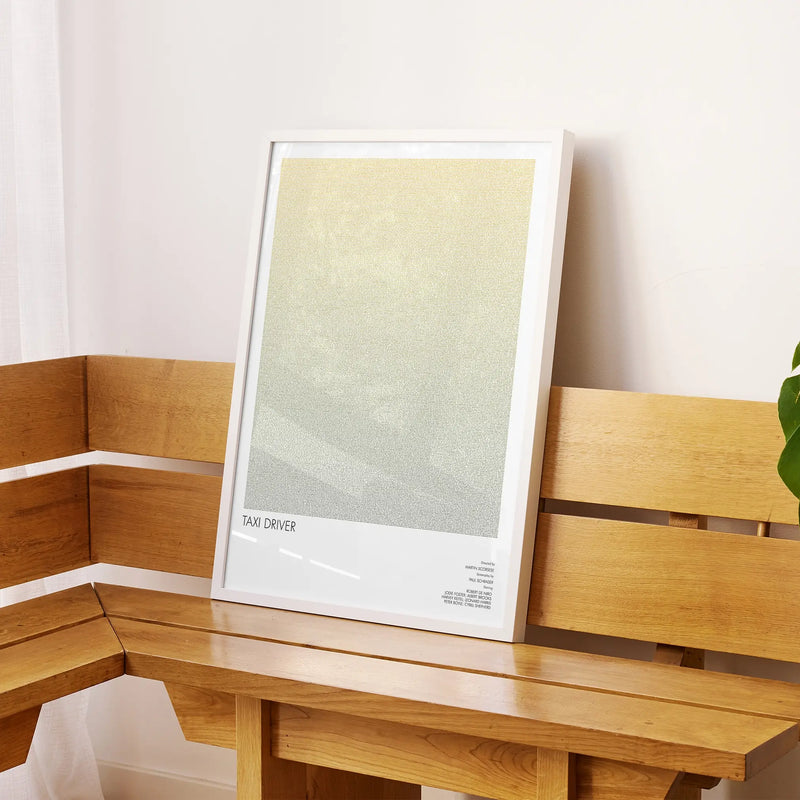 A framed Taxi Driver movie script poster displayed on a sideboard in a contemporary space.