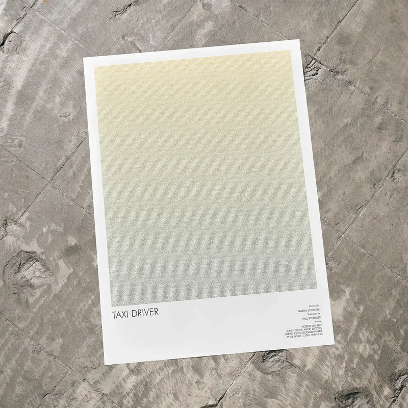 A Taxi Driver movie script poster laid flat on a textured floor surface.