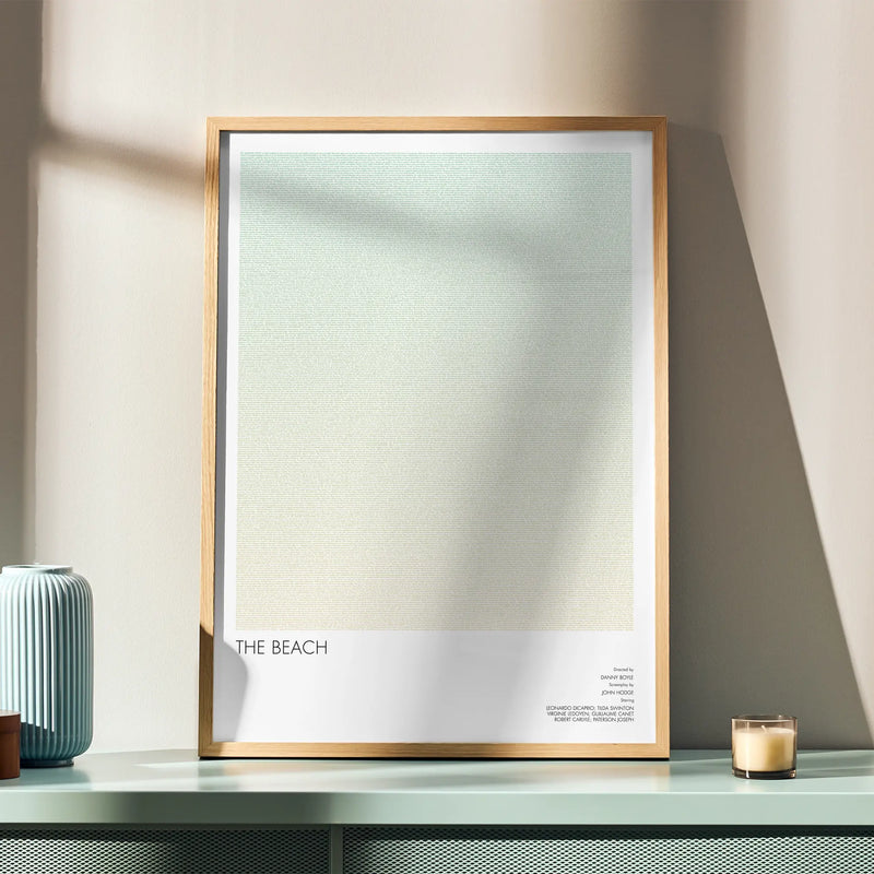 A framed The Beach movie script poster displayed in a simple modern interior.