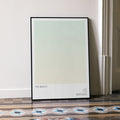A framed The Beach movie script poster leaning against a wall in a minimalist interior.