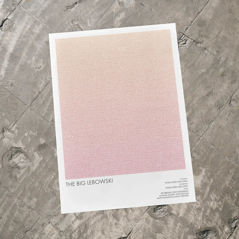 A The Big Lebowski movie script poster laid flat on a textured floor surface.