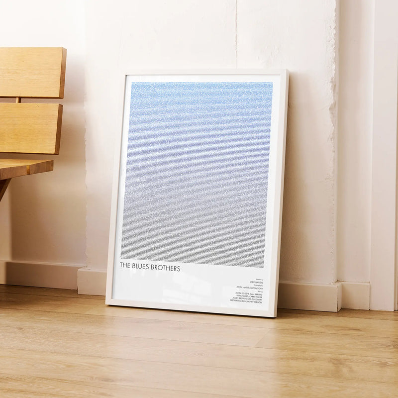 A framed The Blues Brothers movie script poster leaning against a wall in a modern interior.