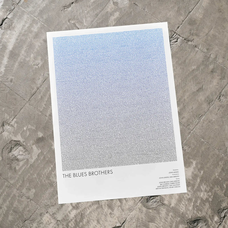 A The Blues Brothers movie script poster laid flat on a textured floor surface.