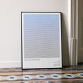A framed The Blues Brothers movie script poster leaning against a wall in a minimalist interior.