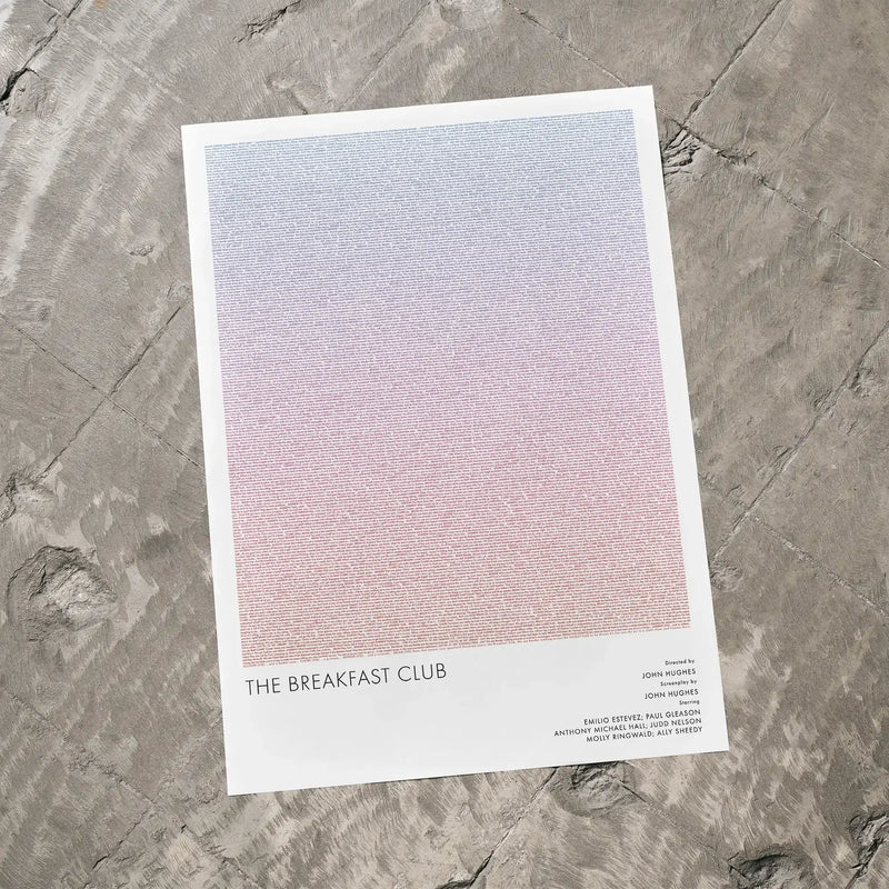 A The Breakfast Club movie script poster laid flat on a textured floor surface.