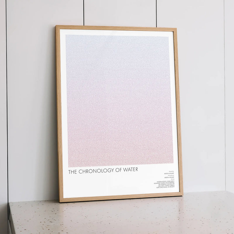 A framed The Chronology of Water movie script poster styled within a calm interior space.