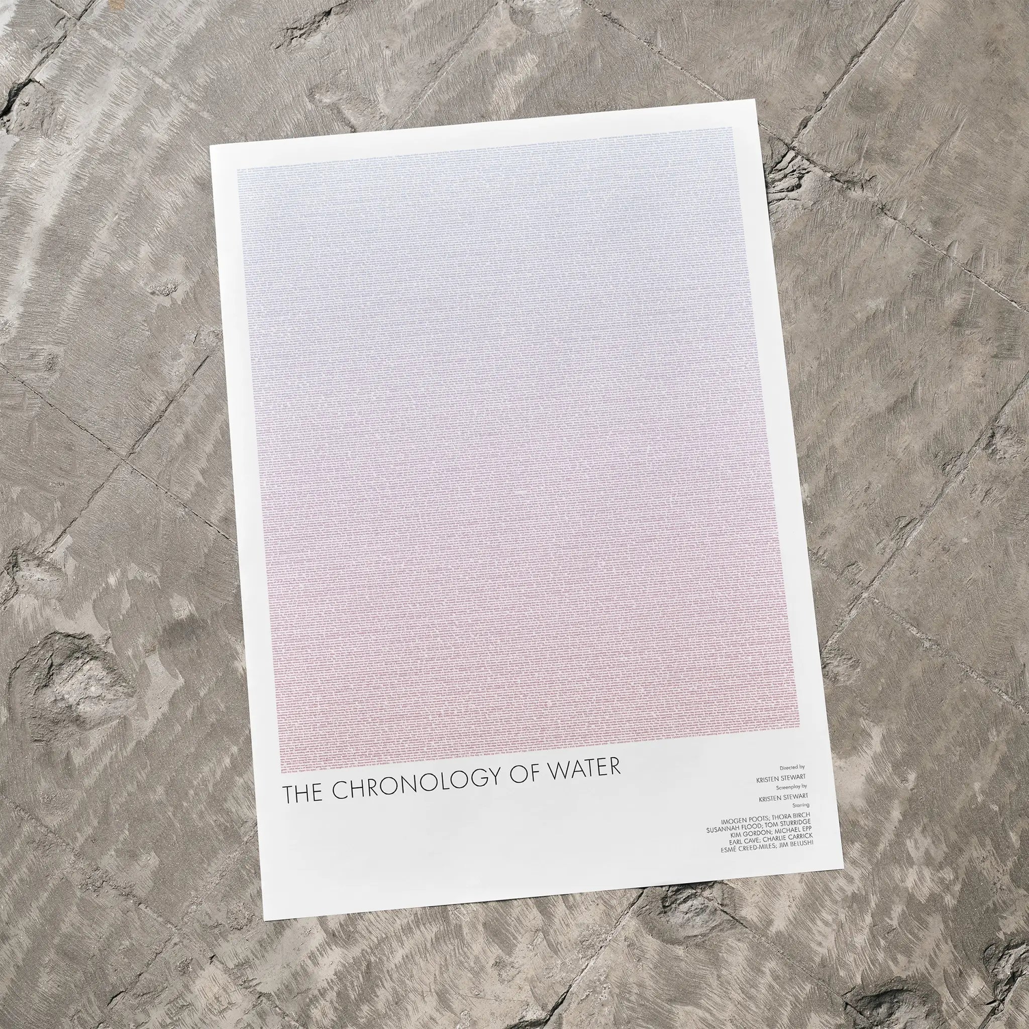 A The Chronology of Water movie script poster laid flat on a textured floor surface.