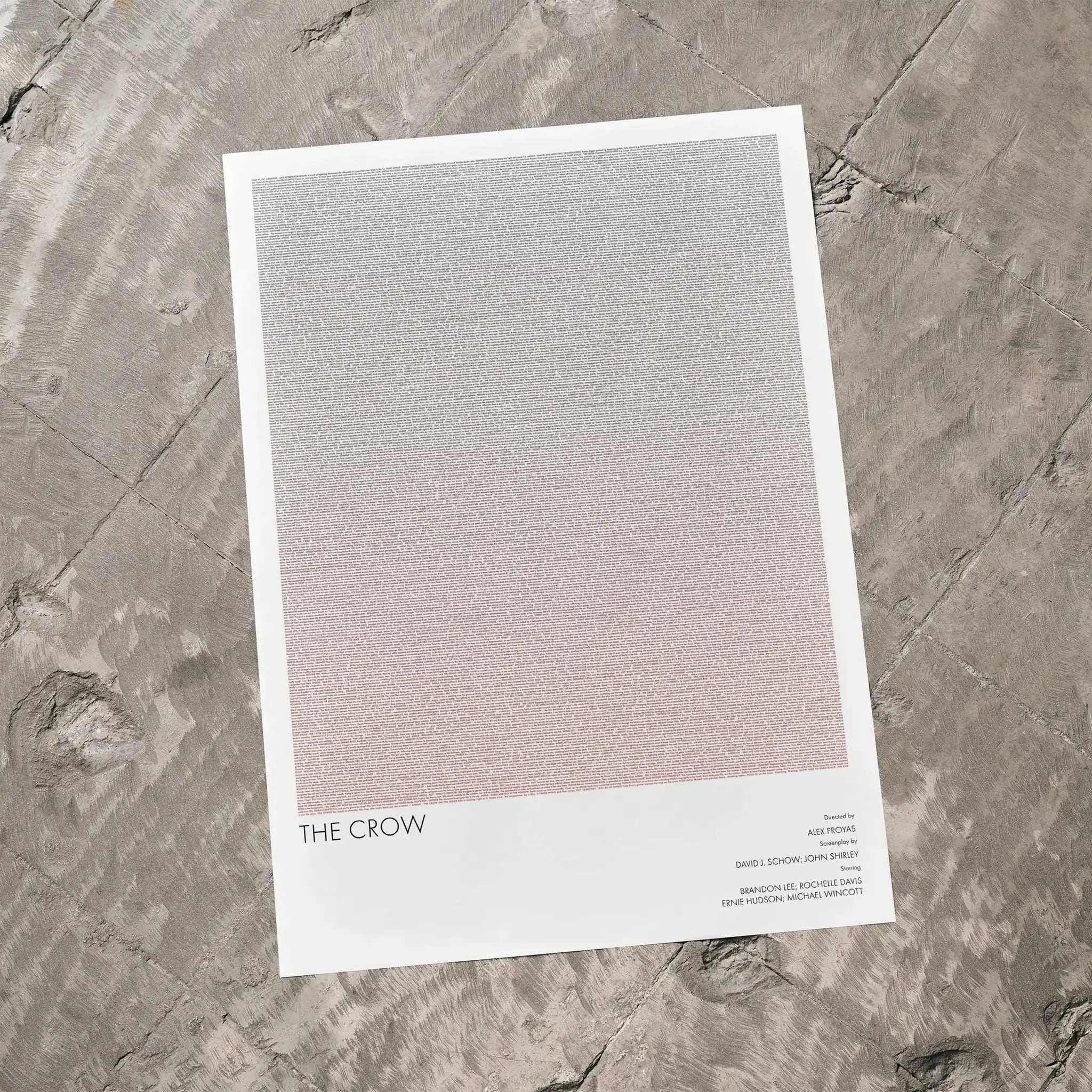 A The Crow movie script poster laid flat on a textured floor surface.