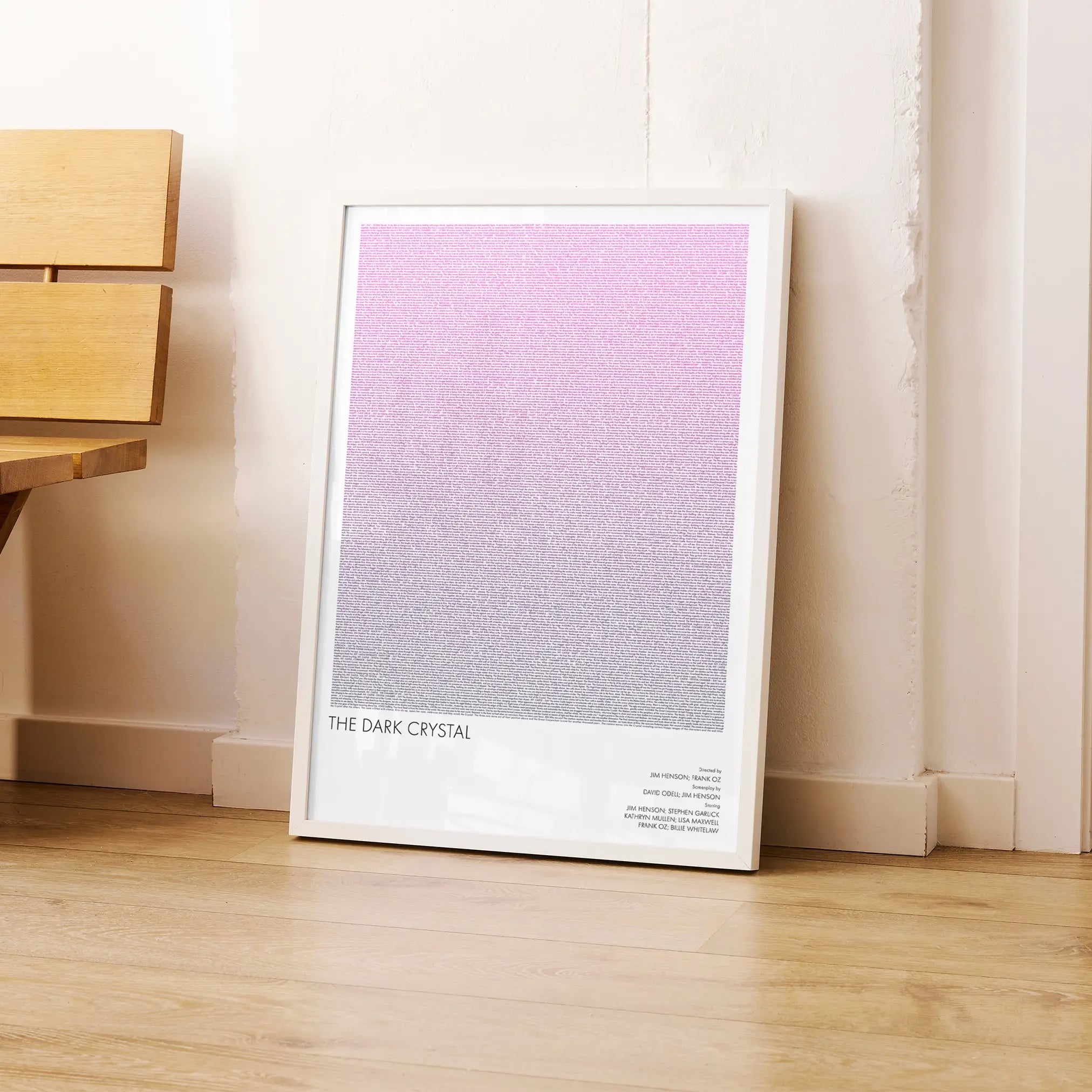 A framed The Dark Crystal movie script poster leaning against a wall in a modern interior.