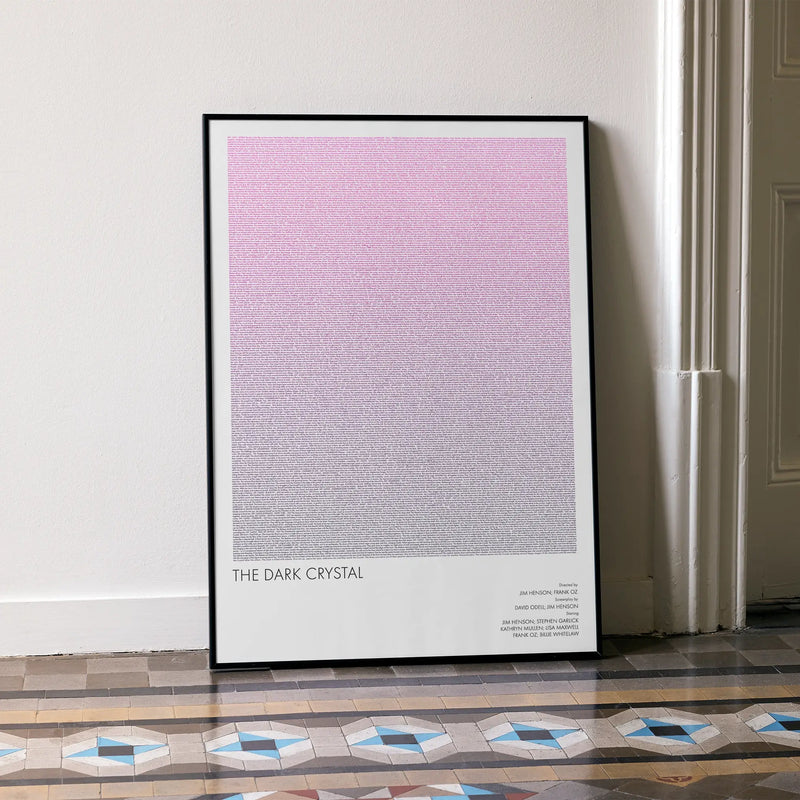 A framed The Dark Crystal movie script poster leaning against a wall in a minimalist interior.