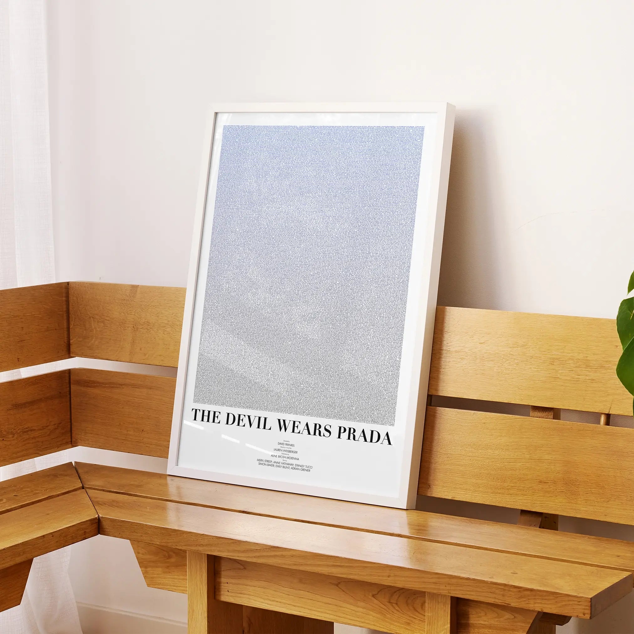 A framed The Devil Wears Prada movie script poster displayed on a sideboard in a contemporary space.