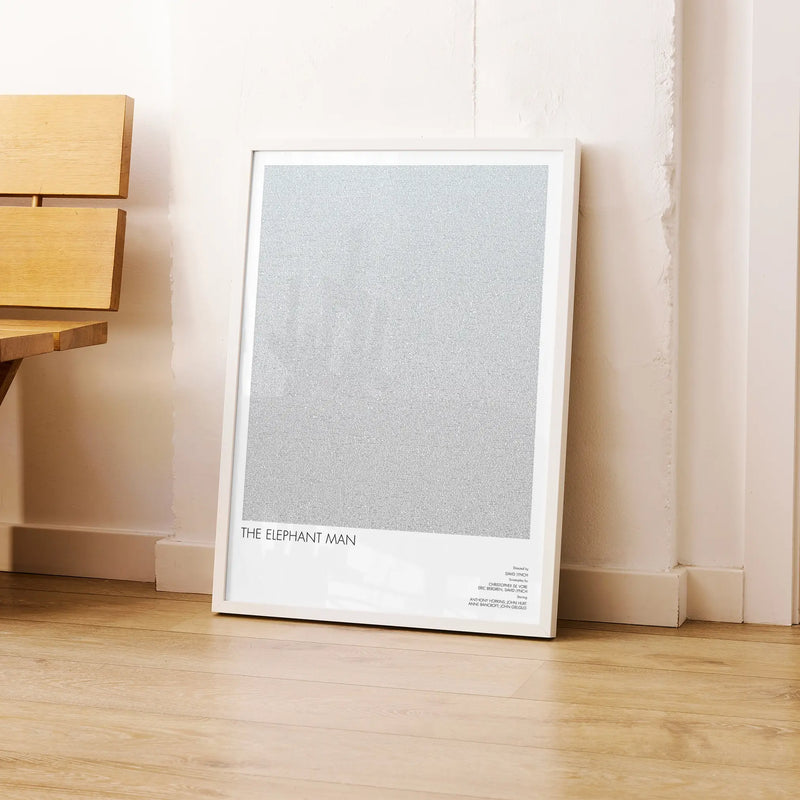 A framed The Elephant Man movie script poster leaning against a wall in a modern interior.