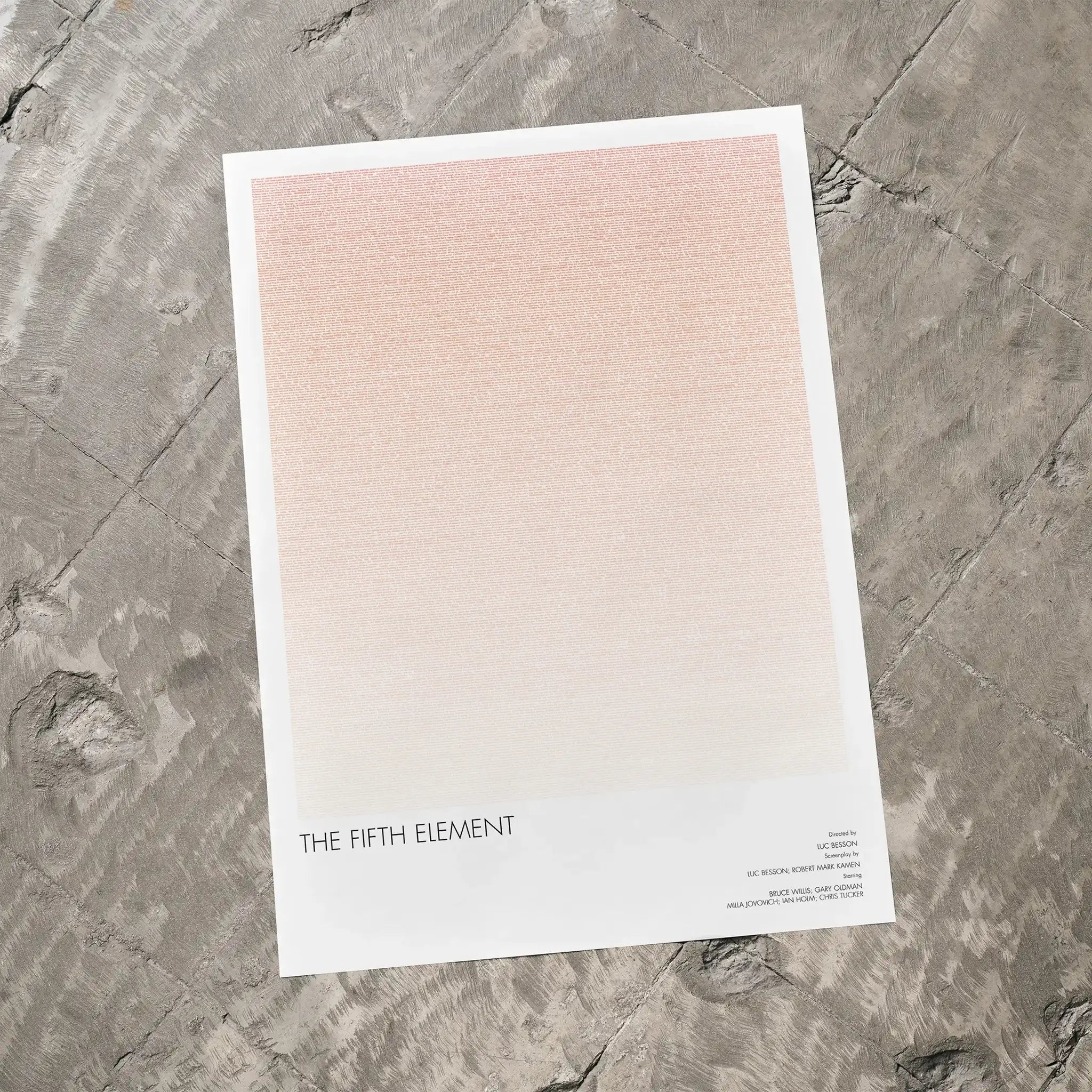 A The Fifth Element movie script poster laid flat on a textured floor surface.