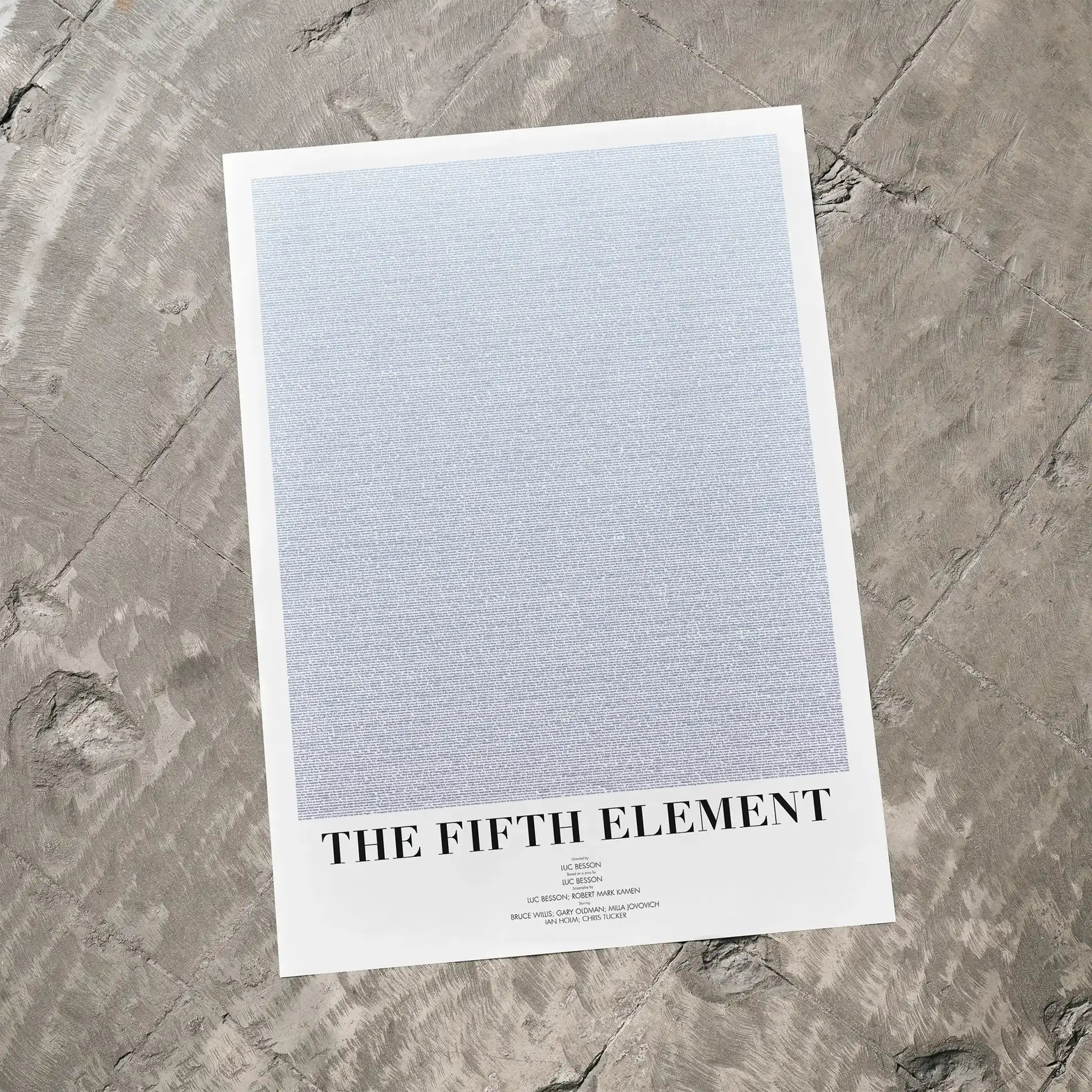 A The Fifth Element movie script poster laid flat on a textured floor surface.