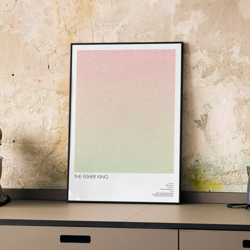 A framed The Fisher King movie script poster displayed on a cabinet in a minimalist interior.
