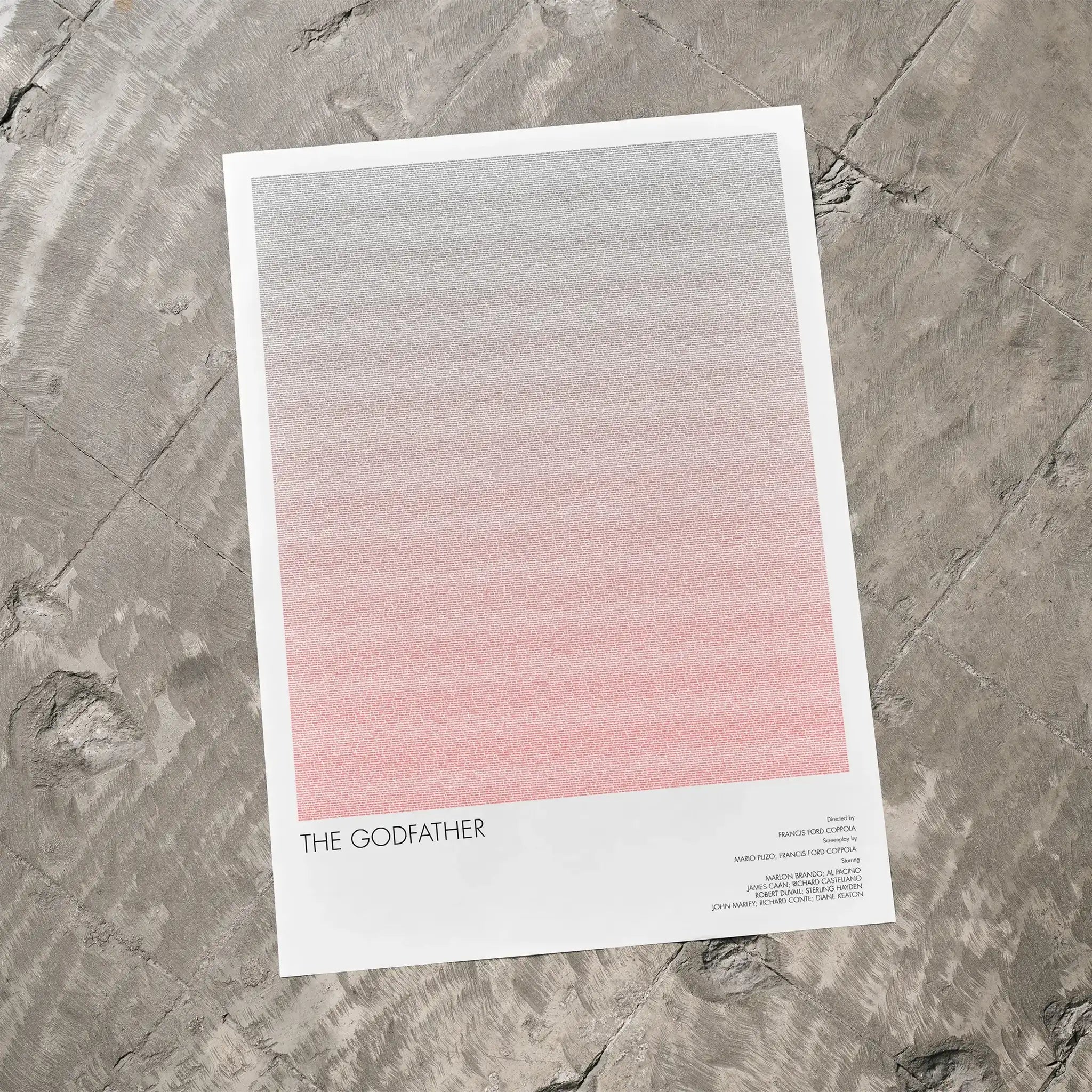 A The Godfather movie script poster laid flat on a textured floor surface.