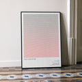 A framed The Godfather movie script poster leaning against a wall in a minimalist interior.
