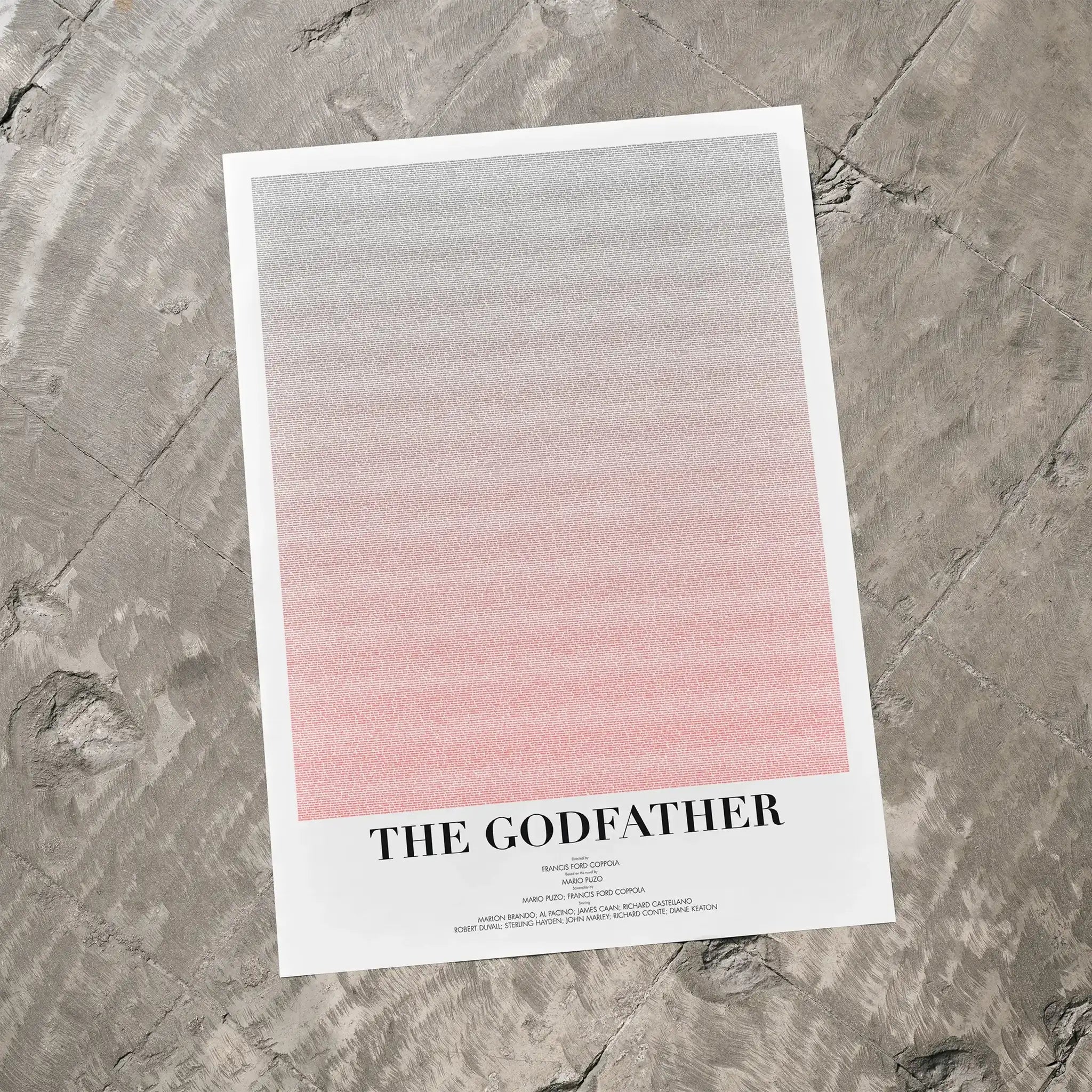 A The Godfather movie script poster laid flat on a textured floor surface.