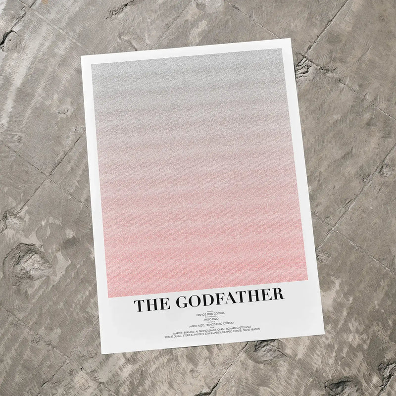 A The Godfather movie script poster laid flat on a textured floor surface.