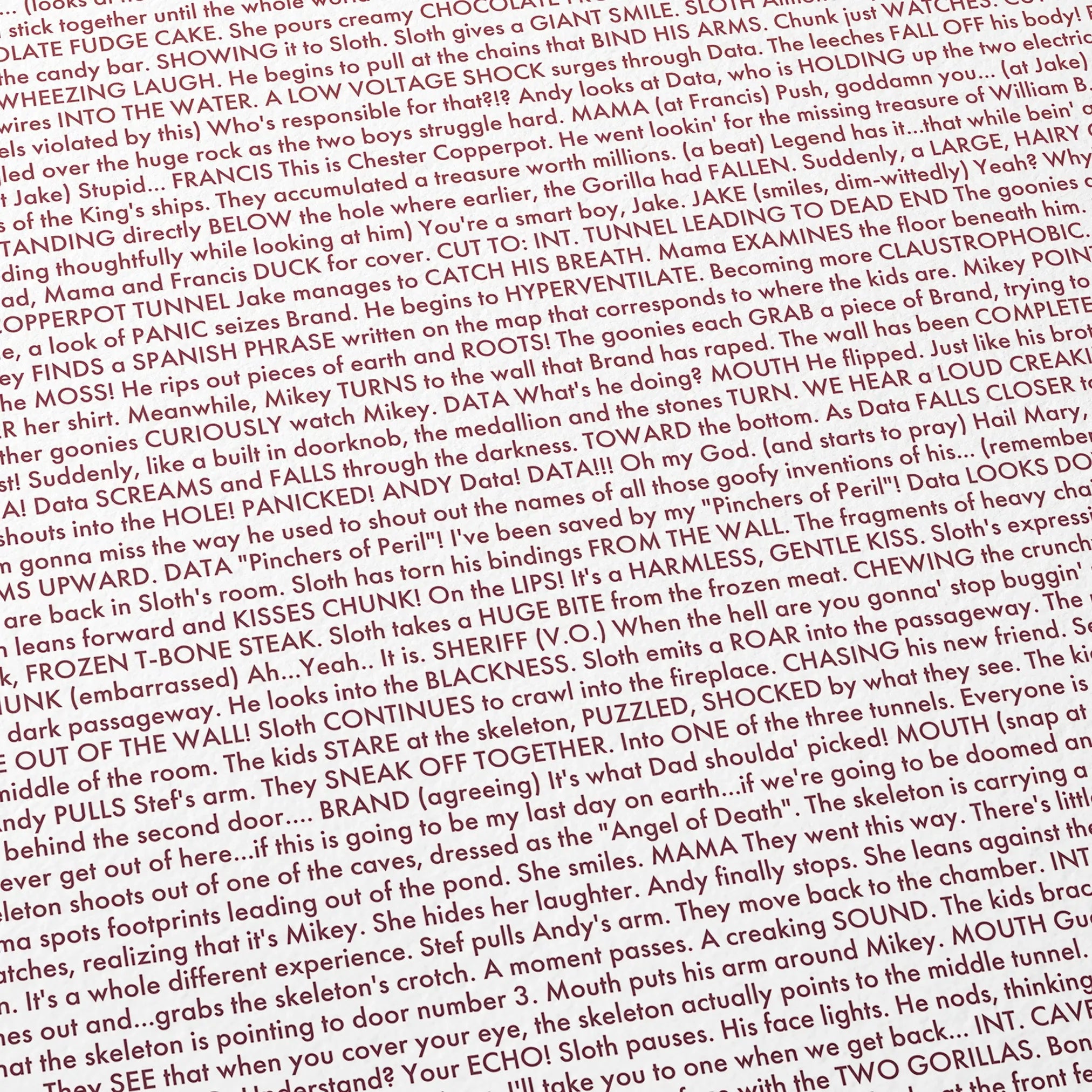 Close-up detail of the The Goonies movie script poster showing dense typographic text.