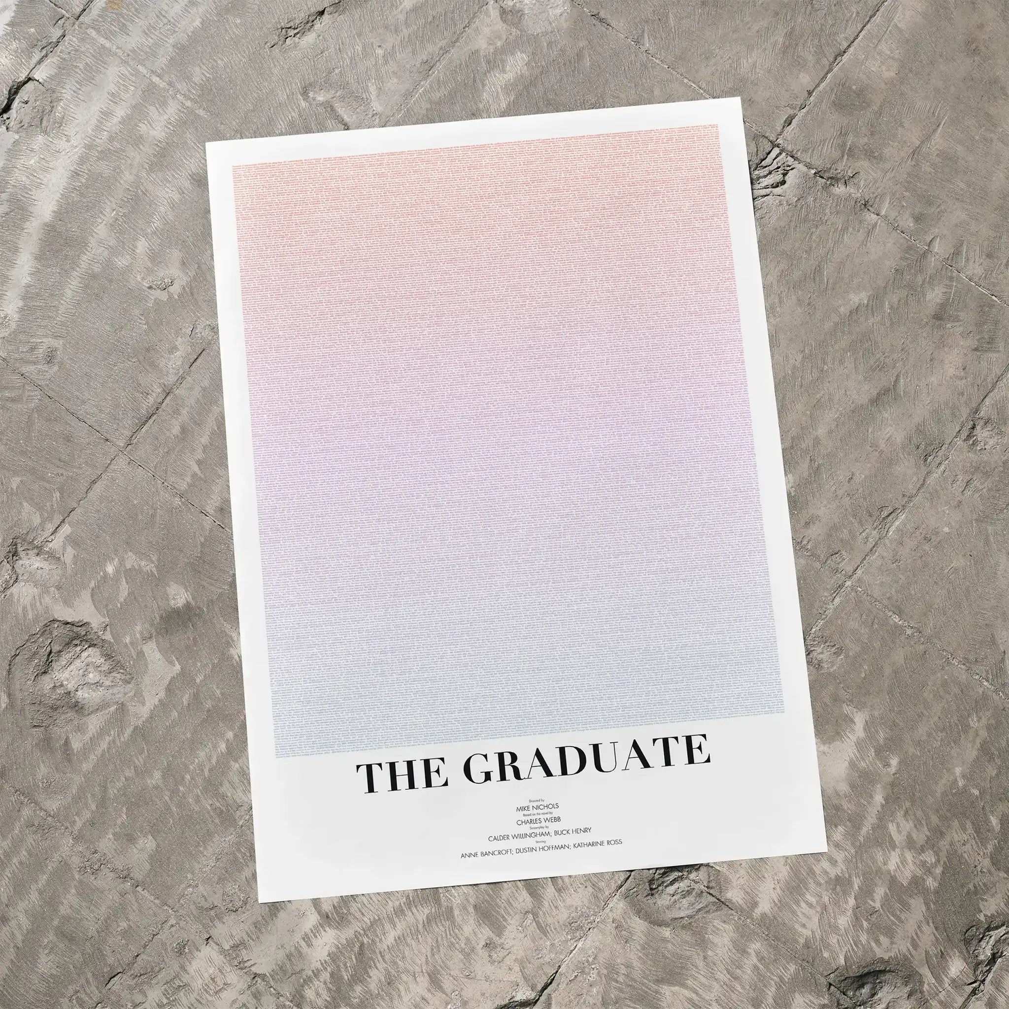 A The Graduate movie script poster laid flat on a textured floor surface.