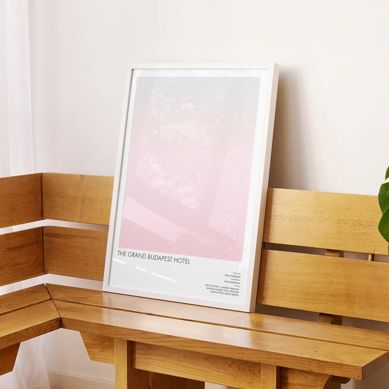 A framed The Grand Budapest Hotel movie script poster displayed on a sideboard in a contemporary space.