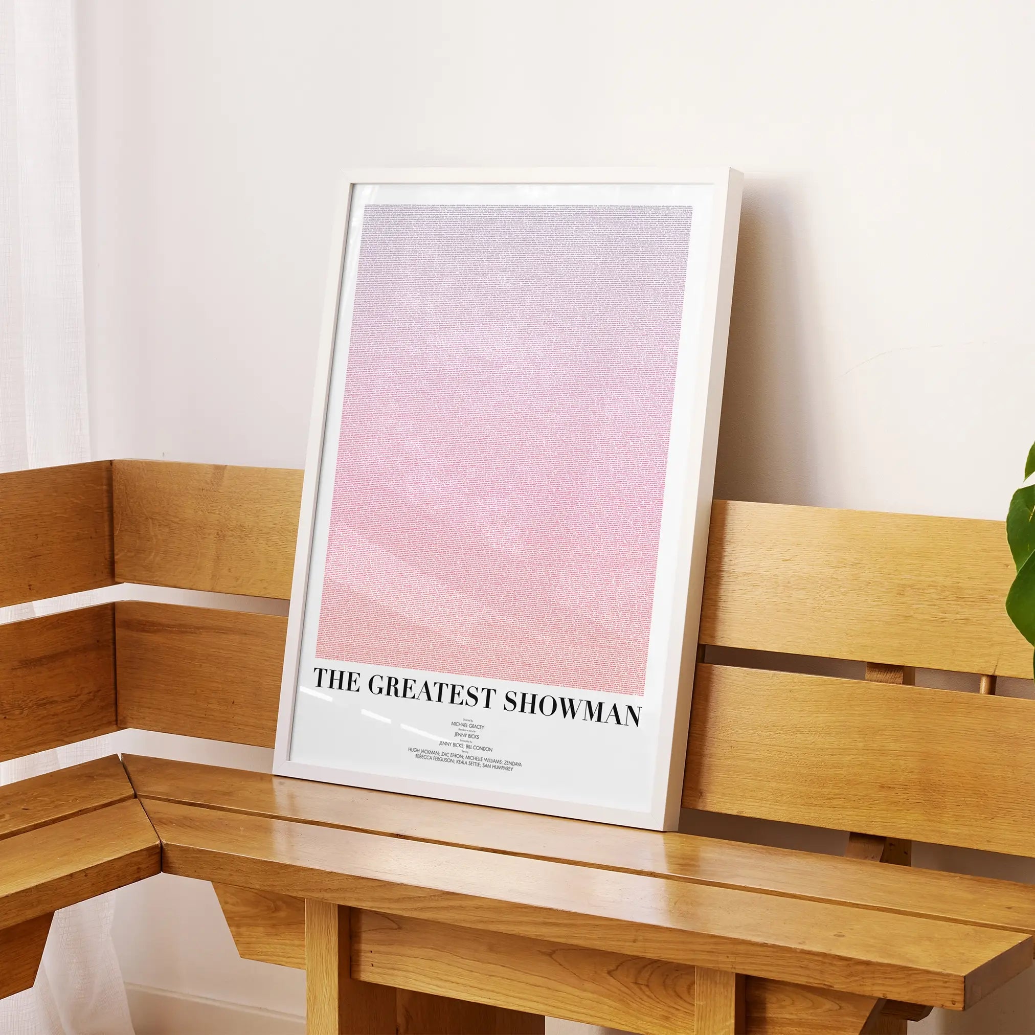 A framed The Greatest Showman movie script poster displayed on a sideboard in a contemporary space.