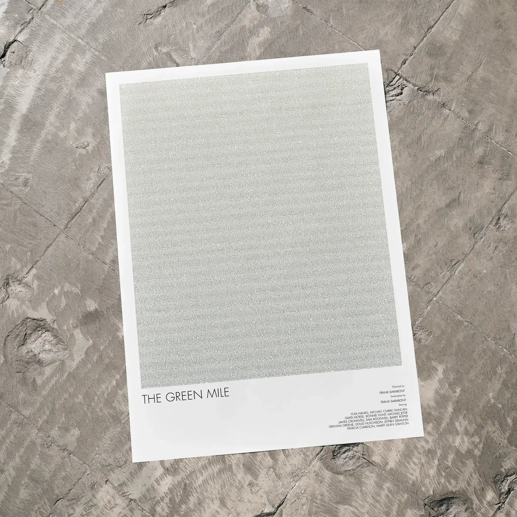 A The Green Mile movie script poster laid flat on a textured floor surface.