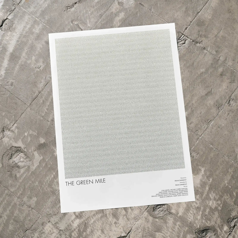 A The Green Mile movie script poster laid flat on a textured floor surface.
