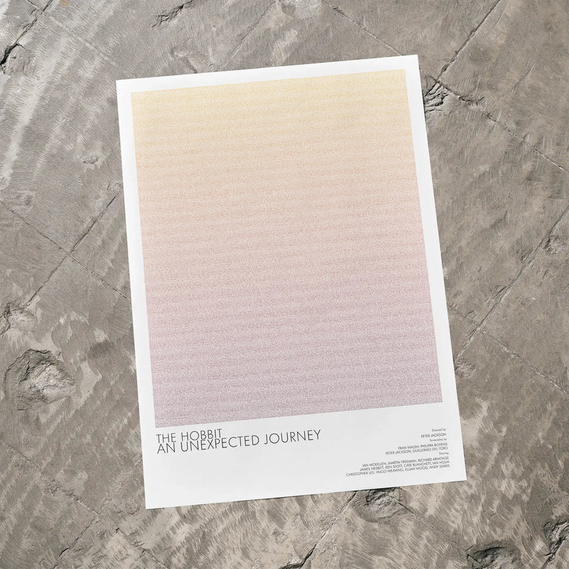 A The Hobbit: An Unexpected Journey movie script poster laid flat on a textured floor surface.