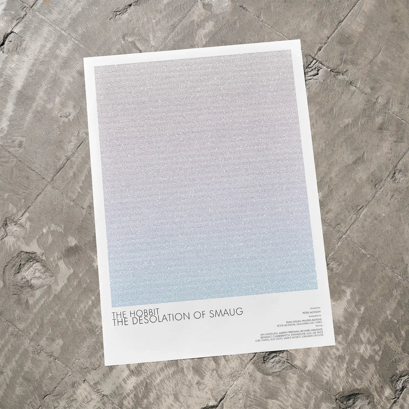A The Hobbit: The Desolation of Smaug movie script poster laid flat on a textured floor surface.