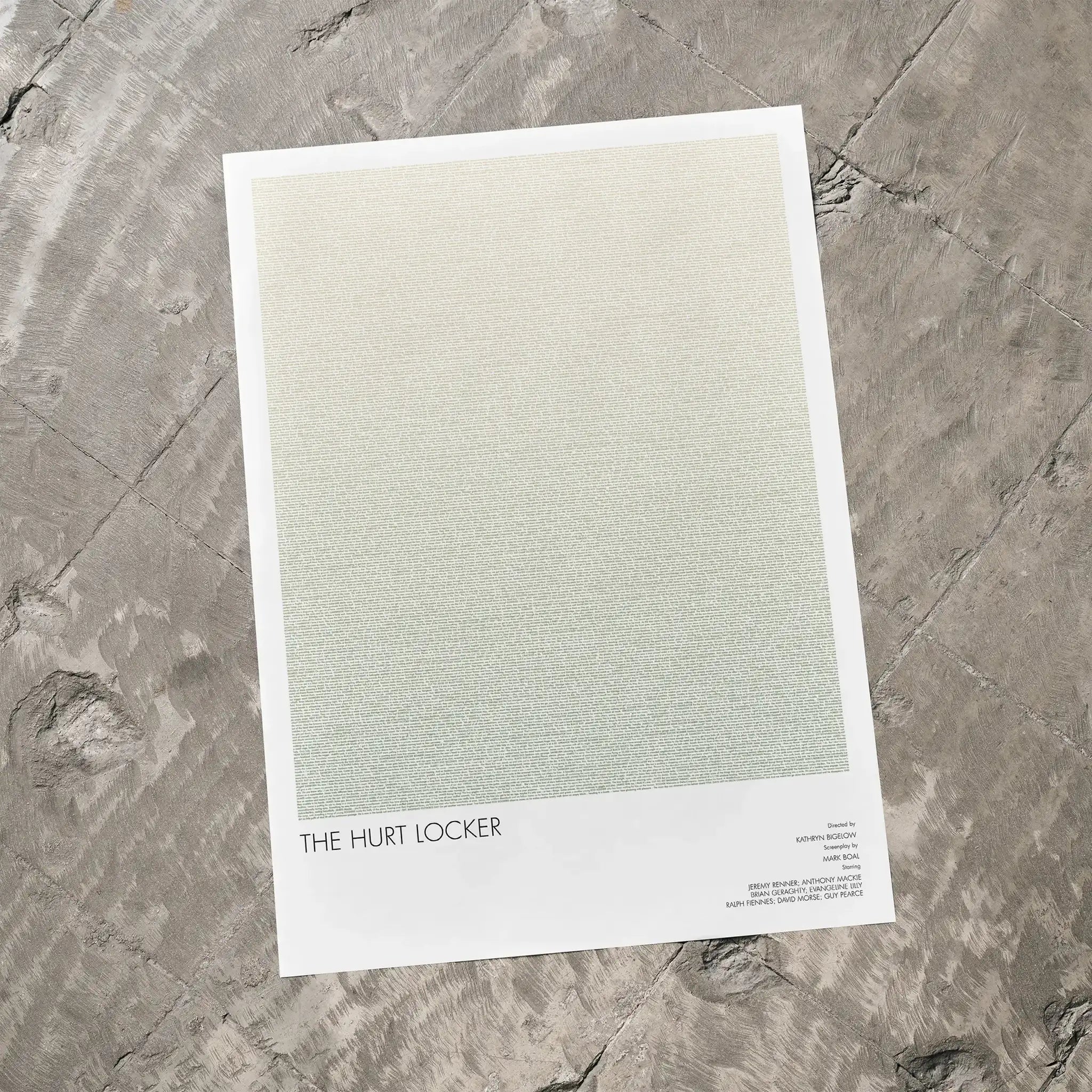 A The Hurt Locker movie script poster laid flat on a textured floor surface.