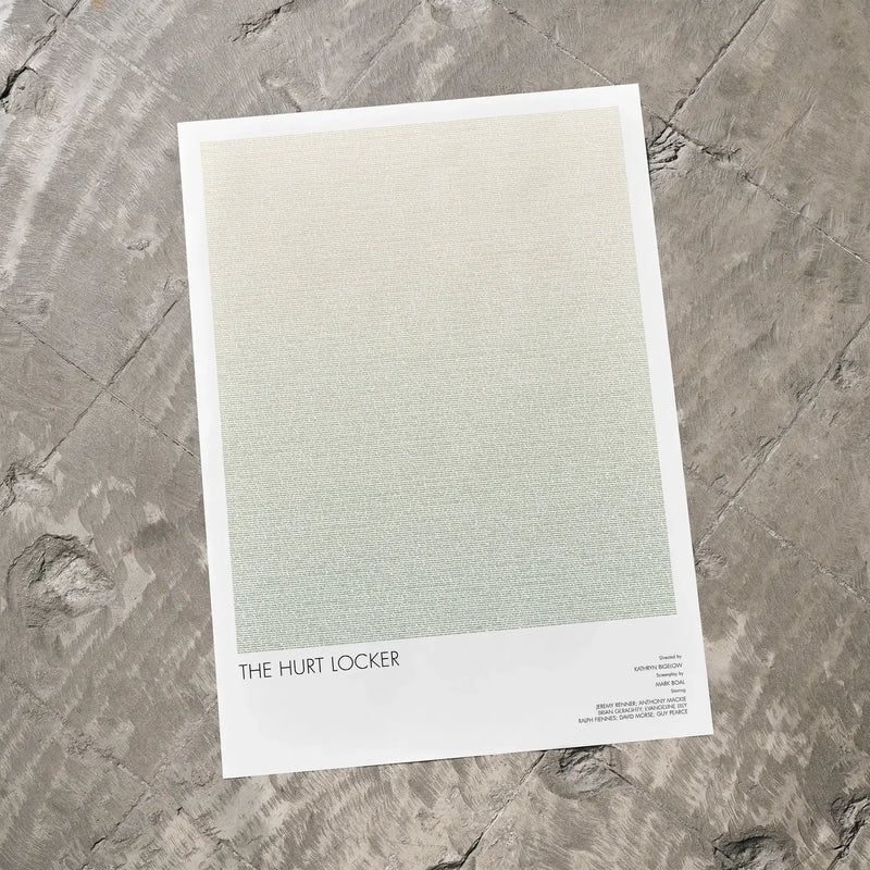 A The Hurt Locker movie script poster laid flat on a textured floor surface.