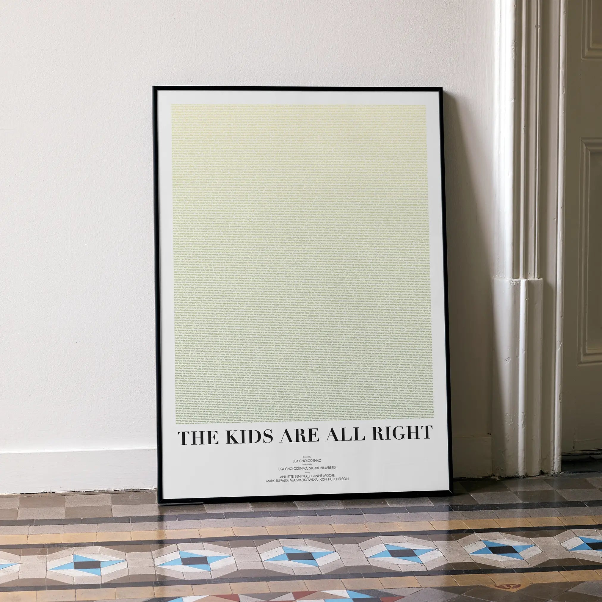 A framed The Kids Are All Right movie script poster leaning against a wall in a minimalist interior.