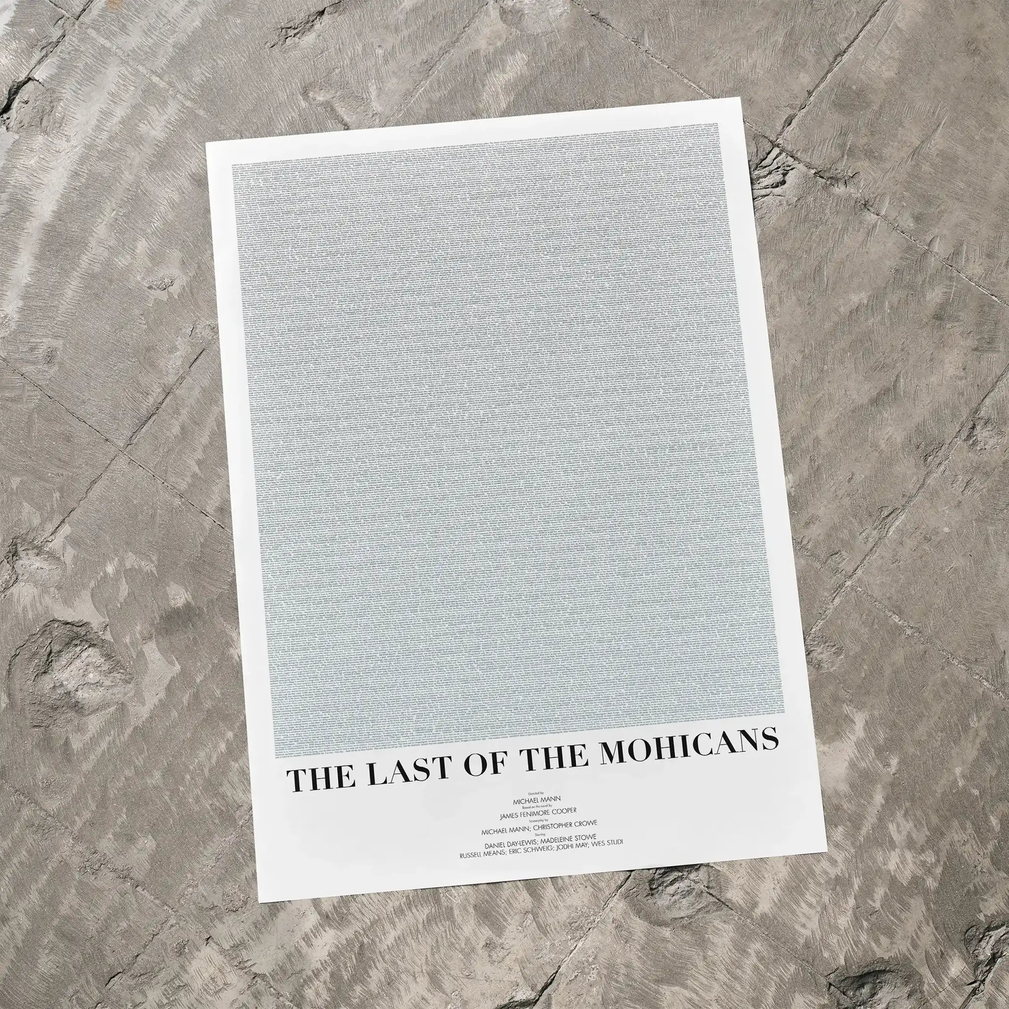A The Last of the Mohicans movie script poster laid flat on a textured floor surface.