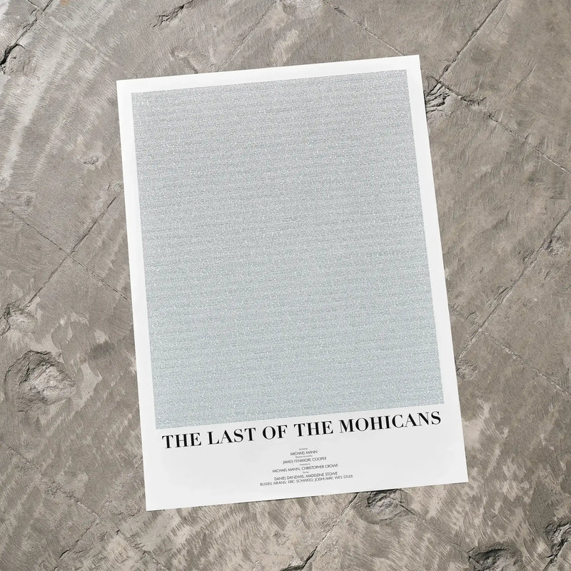 A The Last of the Mohicans movie script poster laid flat on a textured floor surface.