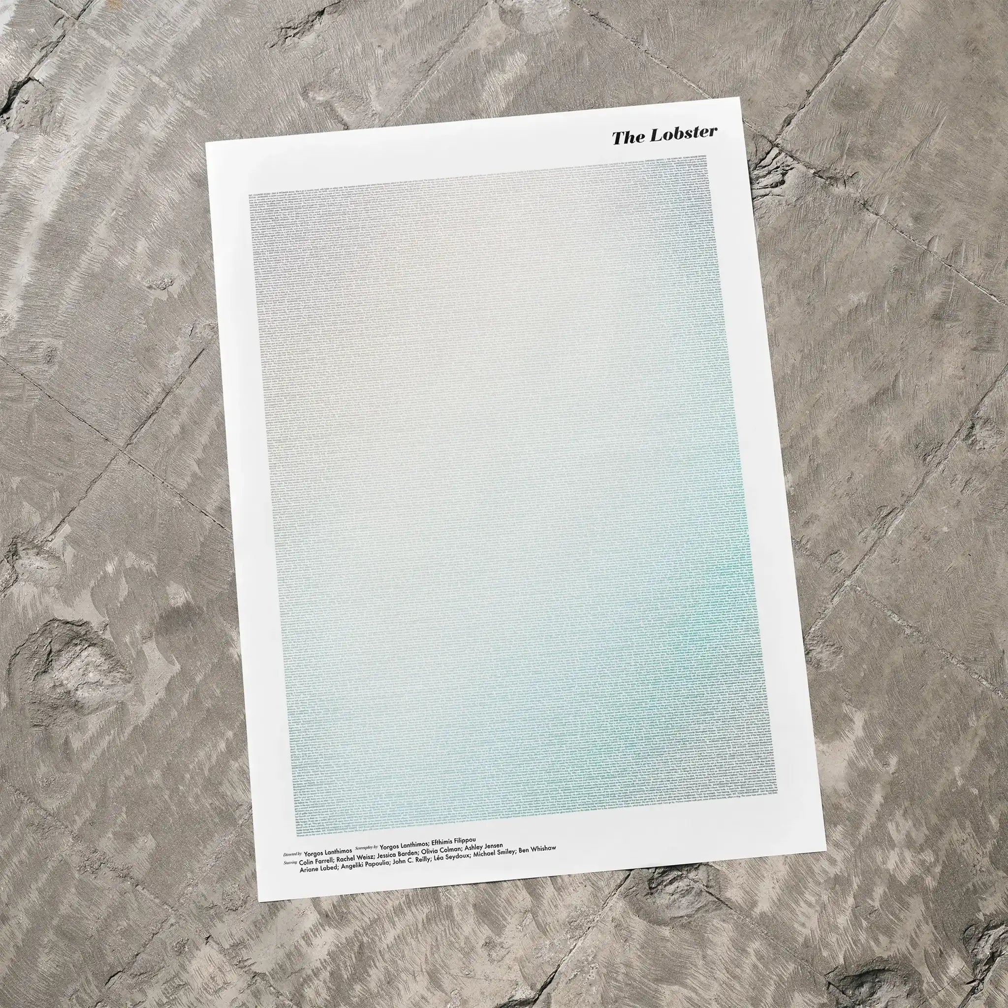 A The Lobster movie script poster laid flat on a textured floor surface.