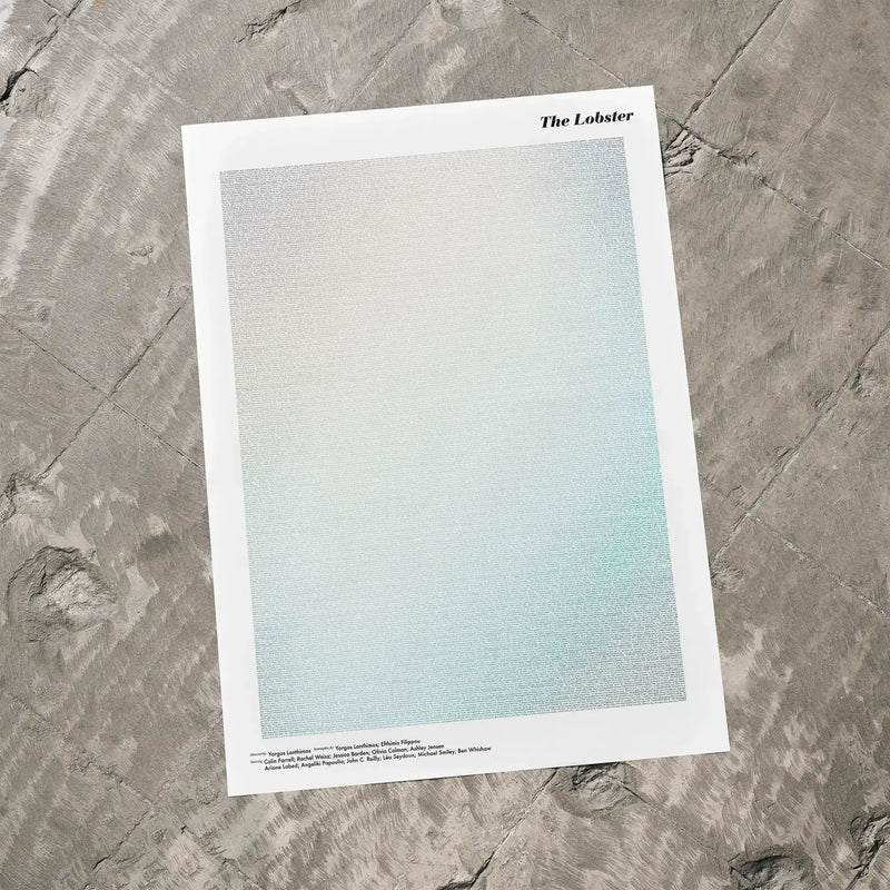 A The Lobster movie script poster laid flat on a textured floor surface.