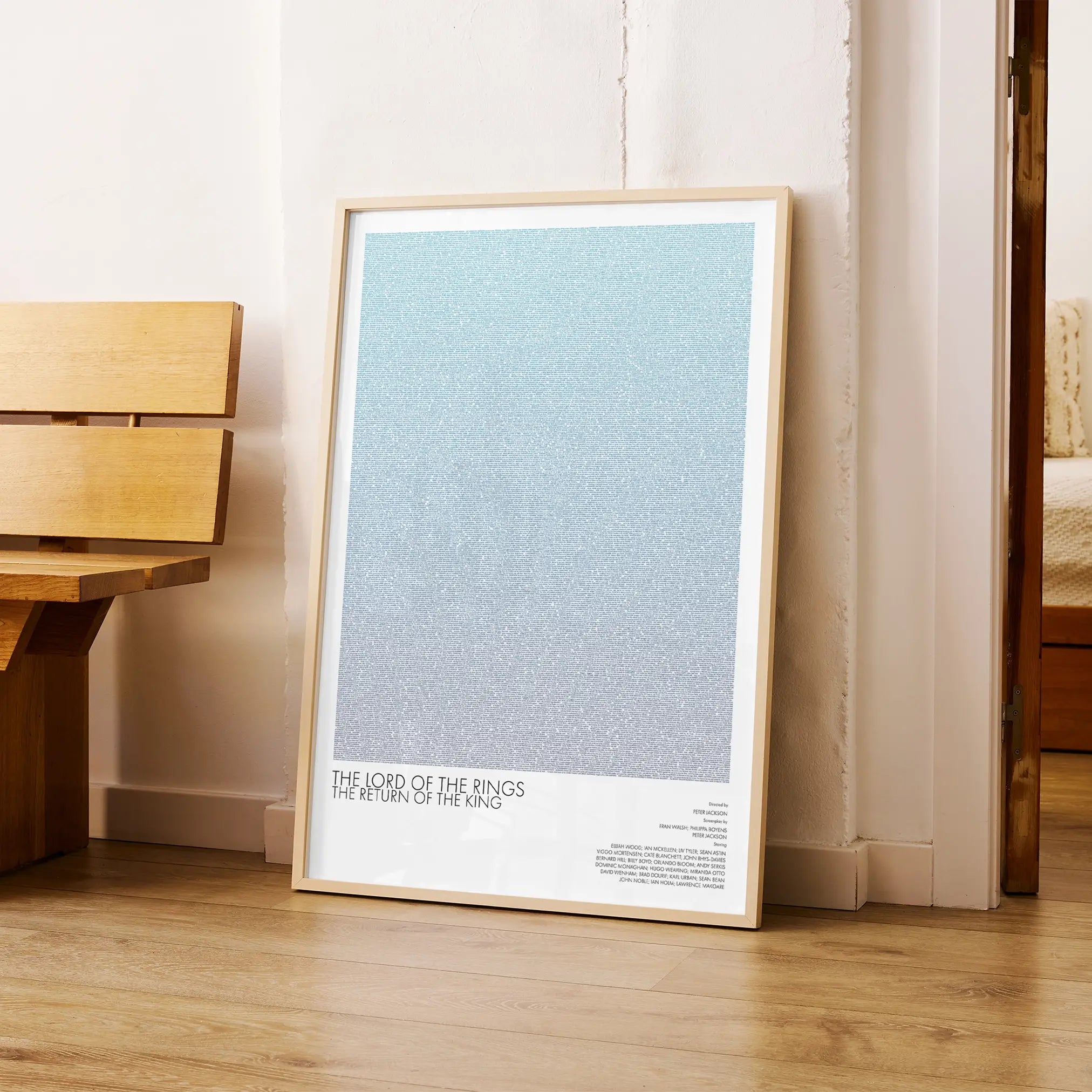A framed The Lord of the Rings: The Return of the King movie script poster arranged in a minimalist interior setting.