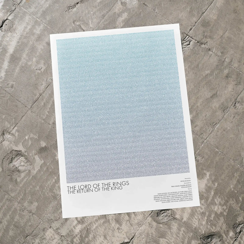 A The Lord of the Rings: The Return of the King movie script poster laid flat on a textured floor surface.