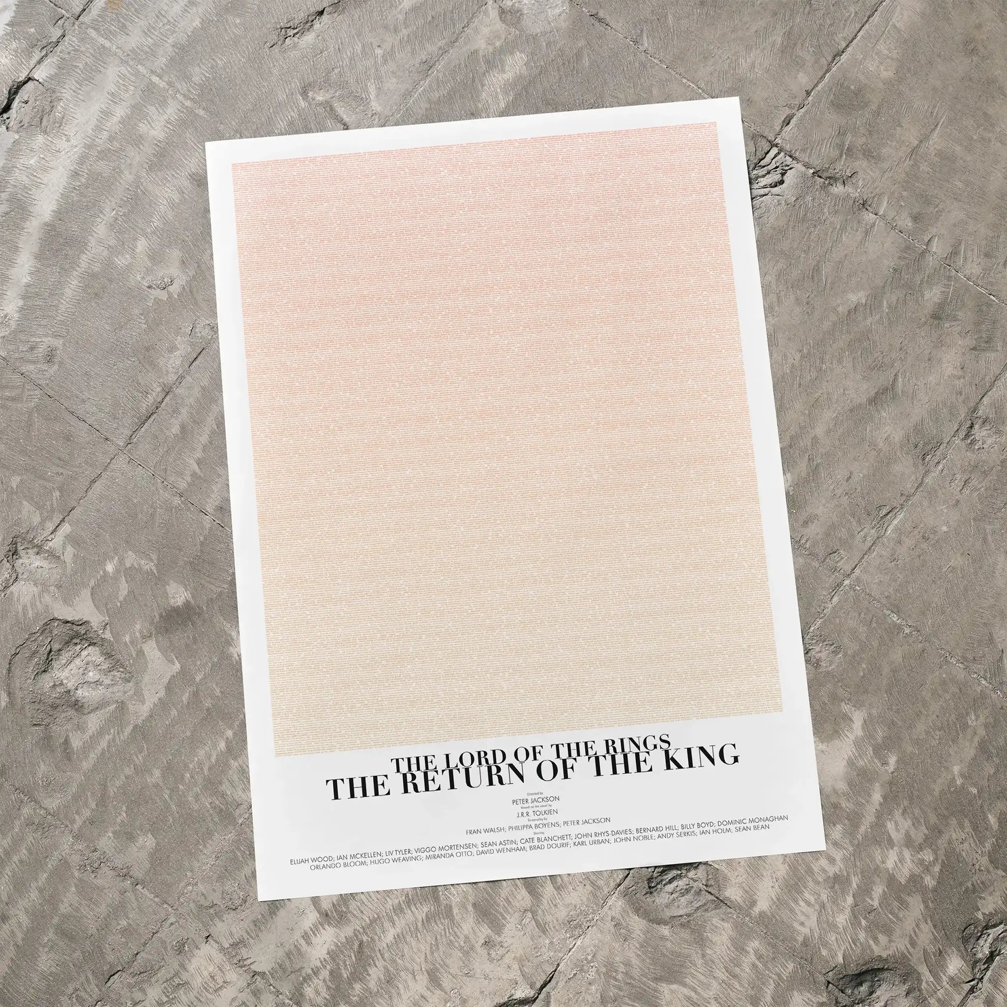 A The Lord of the Rings: The Return of the King movie script poster laid flat on a textured floor surface.