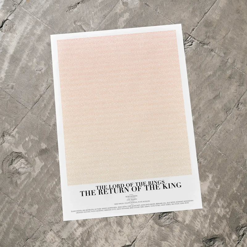 A The Lord of the Rings: The Return of the King movie script poster laid flat on a textured floor surface.